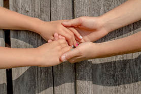 Two Women Holding Hands Supporting Each Other | Advanced Therapy Institute of Touch