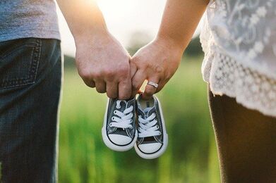 Married Man & Woman Holding Baby Shoes | Advanced Therapy Institute of Touch Gives Back To MOPS Mom's Group