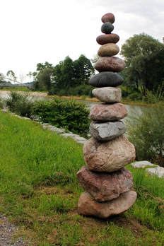 Stacked Rocks On Green Grass | Advanced Therapy Institute of Touch